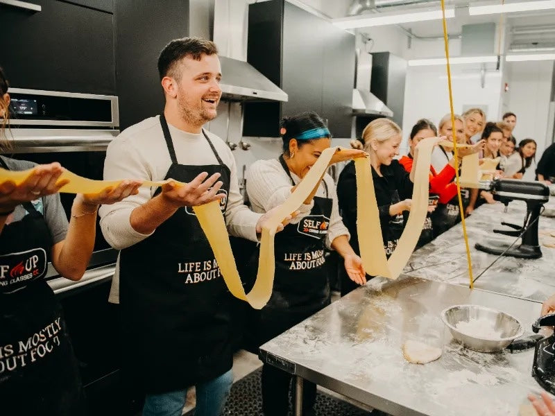 Cooking Team Building Activities | team holding pasta dough